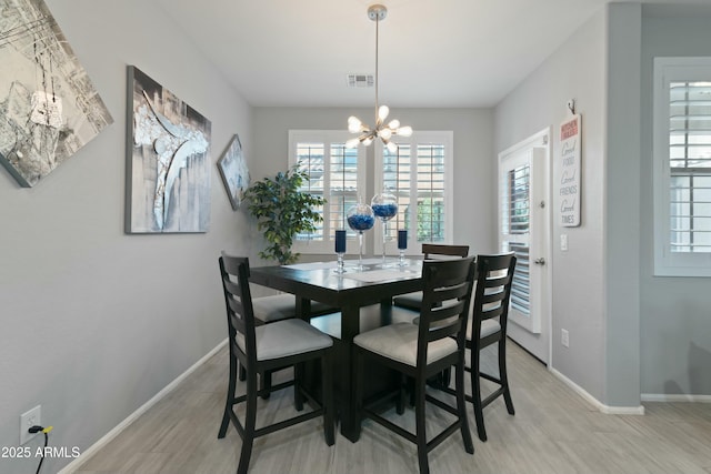 dining room with an inviting chandelier and light wood-type flooring