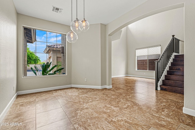 6245 W Maya Dr, Phoenix, AZ 85083 - unfurnished dining area featuring arched walkways, stairs, and baseboards