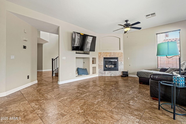 6245 W Maya Dr, Phoenix, AZ 85083 - living room featuring ceiling fan, baseboards, a tile fireplace, built in shelves, and stairs