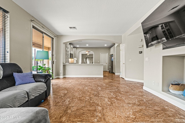6245 W Maya Dr, Phoenix, AZ 85083 - living room featuring arched walkways, baseboards, and a textured ceiling