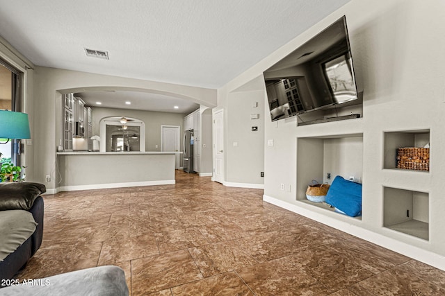 6245 W Maya Dr, Phoenix, AZ 85083 - living room featuring arched walkways, a textured ceiling, and baseboards