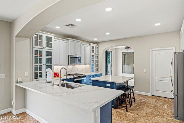 6245 W Maya Dr, Phoenix, AZ 85083 - kitchen featuring appliances with stainless steel finishes, arched walkways, a kitchen island, a peninsula, and a breakfast bar area