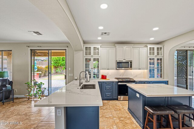 6245 W Maya Dr, Phoenix, AZ 85083 - kitchen with stainless steel appliances, a sink, a breakfast bar area, recessed lighting, and light stone countertops