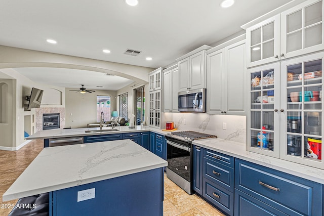 6245 W Maya Dr, Phoenix, AZ 85083 - kitchen with stainless steel appliances, arched walkways, blue cabinets, a peninsula, and recessed lighting
