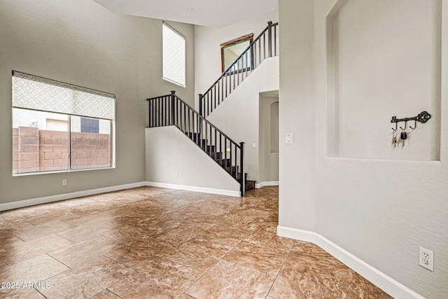 6245 W Maya Dr, Phoenix, AZ 85083 - unfurnished living room featuring healthy amount of natural light, baseboards, a towering ceiling, and stairway
