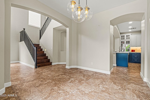 6245 W Maya Dr, Phoenix, AZ 85083 - unfurnished dining area featuring arched walkways, a chandelier, baseboards, stairway, and a sink