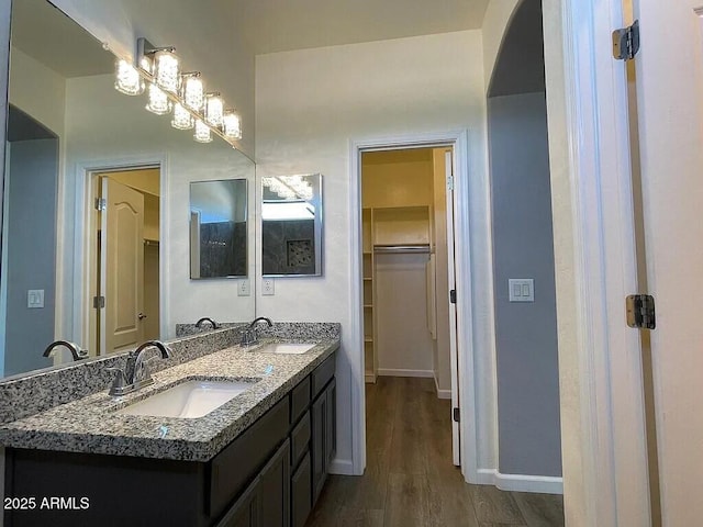 6557 S Classic Way, Gilbert, AZ 85298 - bathroom with wood finished floors, double vanity, a spacious closet, and baseboards