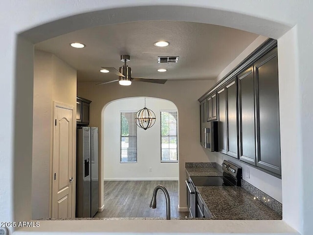 6557 S Classic Way, Gilbert, AZ 85298 - kitchen with appliances with stainless steel finishes, a chandelier, a ceiling fan, arched walkways, and wood finished floors