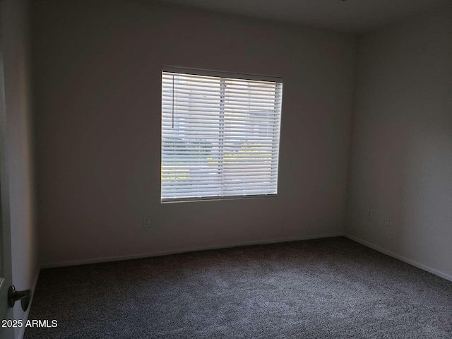 carpeted spare room featuring plenty of natural light and baseboards