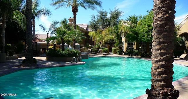 community pool featuring fence and a patio area