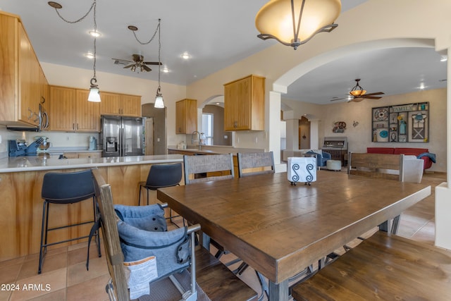 tiled dining space with sink and ceiling fan