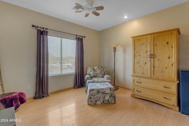 living area with ceiling fan and light hardwood / wood-style flooring