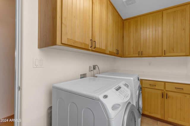 washroom featuring cabinets, light tile patterned floors, and washing machine and dryer