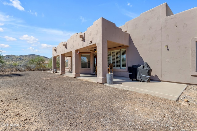 back of house with a mountain view and a patio area