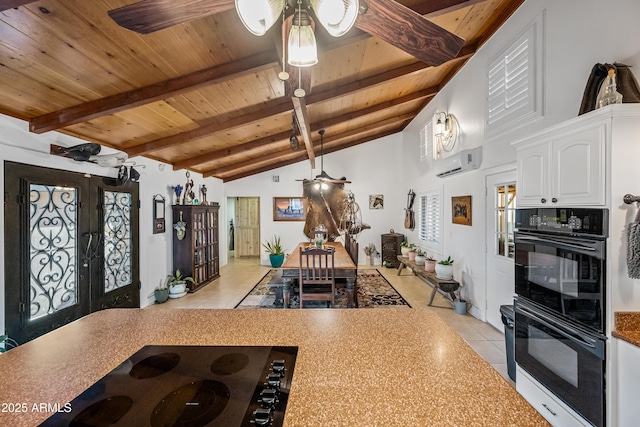 kitchen with french doors, double oven, a wall unit AC, ceiling fan, and white cabinets