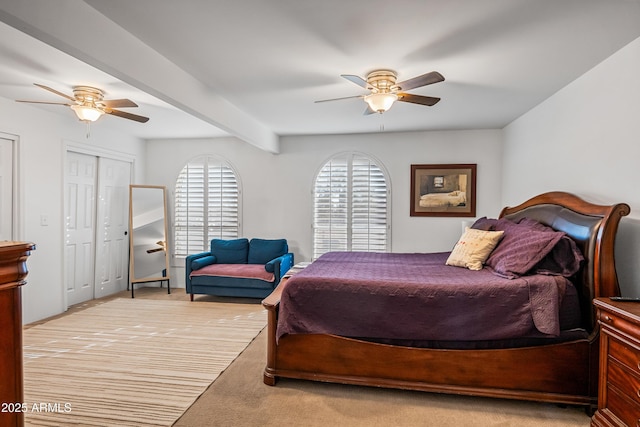 carpeted bedroom featuring beamed ceiling and ceiling fan