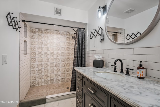 bathroom with vanity, a shower with shower curtain, and tile walls