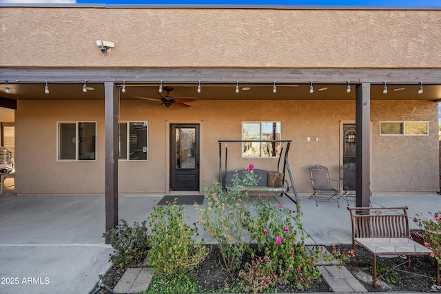 entrance to property featuring ceiling fan and a patio area