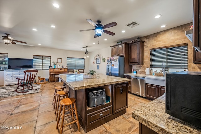 kitchen featuring dark brown cabinets, appliances with stainless steel finishes, and a kitchen island