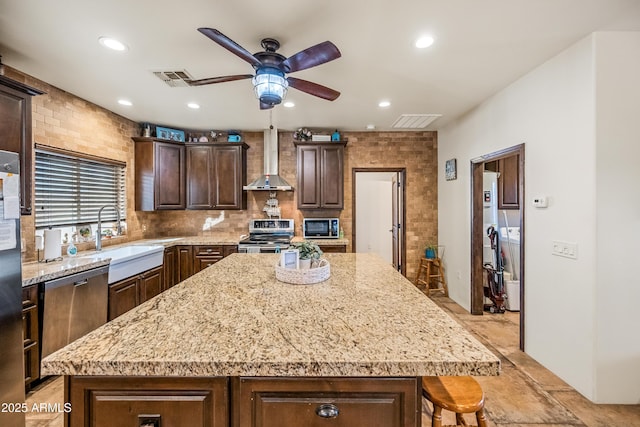 kitchen featuring stainless steel electric range oven, sink, a center island, dark brown cabinets, and wall chimney exhaust hood