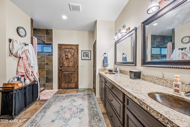 bathroom with vanity and tiled shower