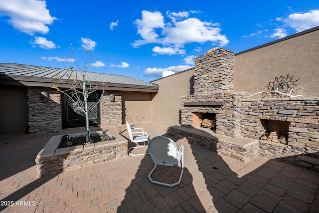 view of patio / terrace featuring an outdoor stone fireplace