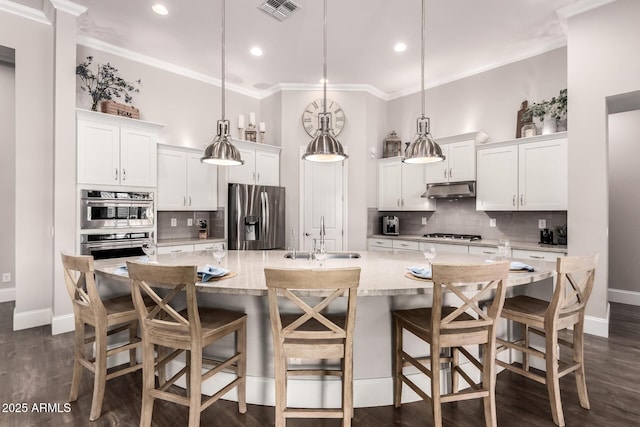 kitchen featuring visible vents, appliances with stainless steel finishes, ornamental molding, a sink, and under cabinet range hood