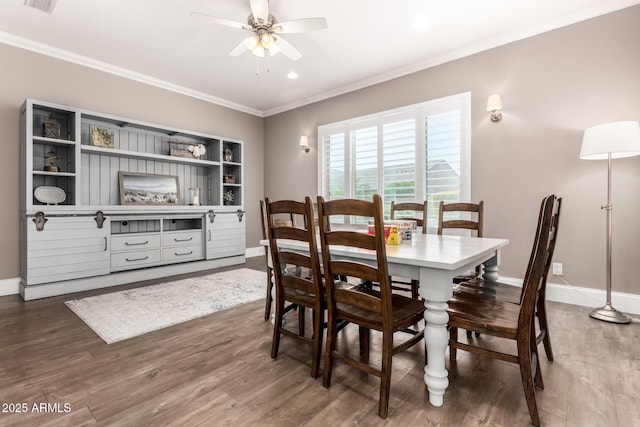 dining space featuring baseboards, visible vents, ceiling fan, ornamental molding, and wood finished floors