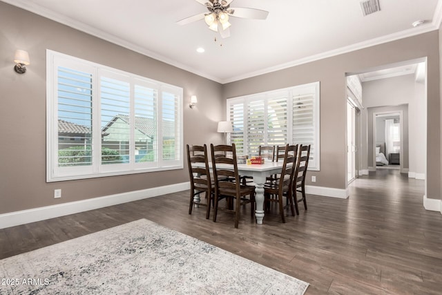 dining room with baseboards, visible vents, ceiling fan, ornamental molding, and wood finished floors