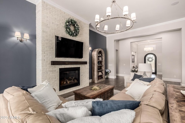 living area with a brick fireplace, baseboards, ornamental molding, and wood finished floors