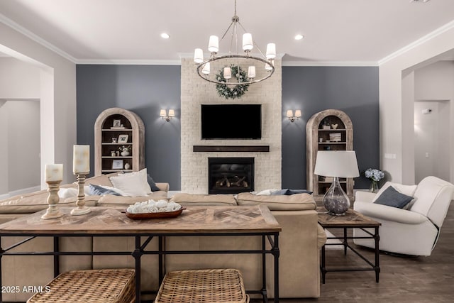 living area with a fireplace, ornamental molding, a chandelier, and wood finished floors