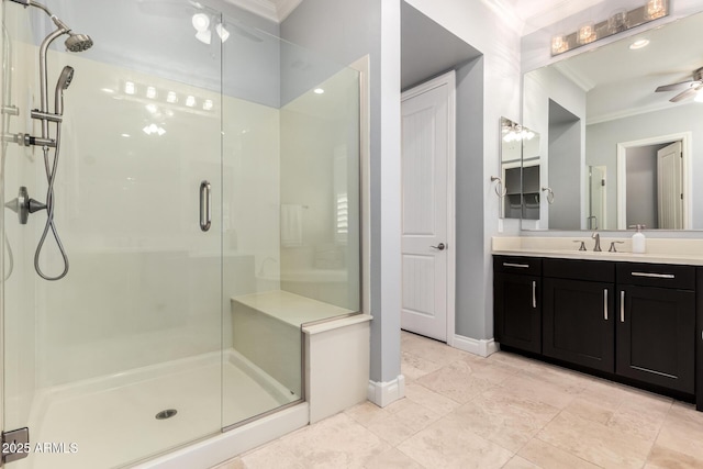 bathroom featuring crown molding, ceiling fan, a shower stall, vanity, and baseboards