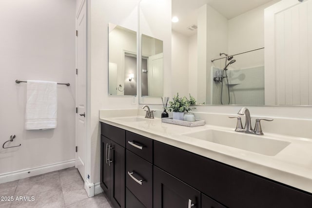 bathroom with a shower, tile patterned flooring, a sink, and baseboards