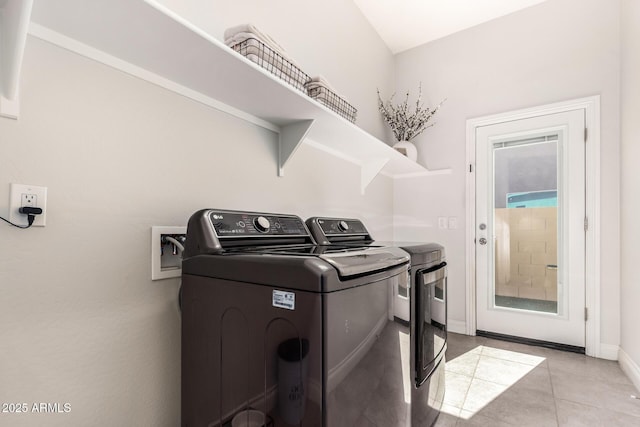 laundry area featuring laundry area, light tile patterned flooring, independent washer and dryer, and baseboards