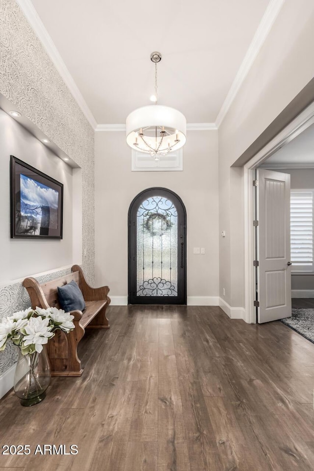 foyer entrance with ornamental molding and baseboards