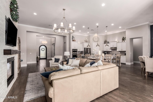 living area featuring ornamental molding, recessed lighting, a stone fireplace, and dark wood-style floors