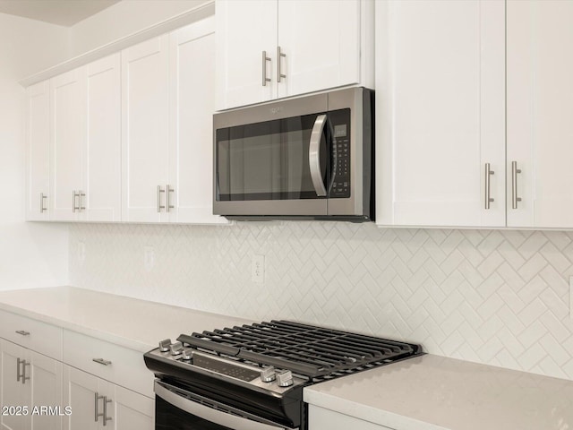 kitchen featuring appliances with stainless steel finishes, tasteful backsplash, and white cabinetry