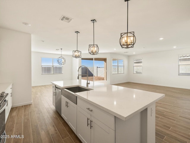 kitchen with a center island with sink, dark hardwood / wood-style floors, and sink