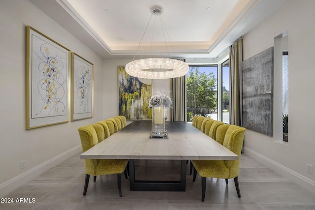 dining room with a notable chandelier and a raised ceiling