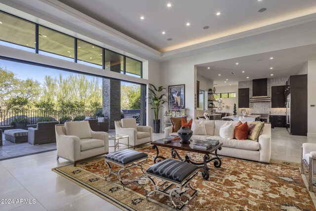 living room with a towering ceiling and light tile patterned floors