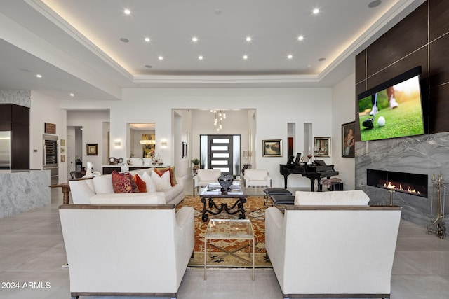 living room featuring a high end fireplace and a raised ceiling