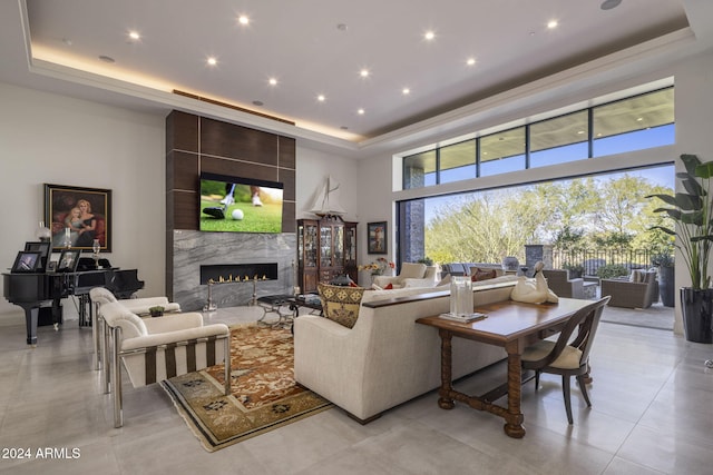 living room with a premium fireplace, a high ceiling, and a raised ceiling