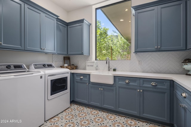 washroom featuring washer and dryer, cabinets, and sink