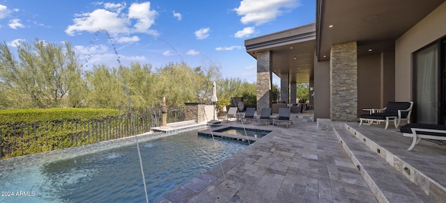 view of swimming pool featuring a patio area and an in ground hot tub