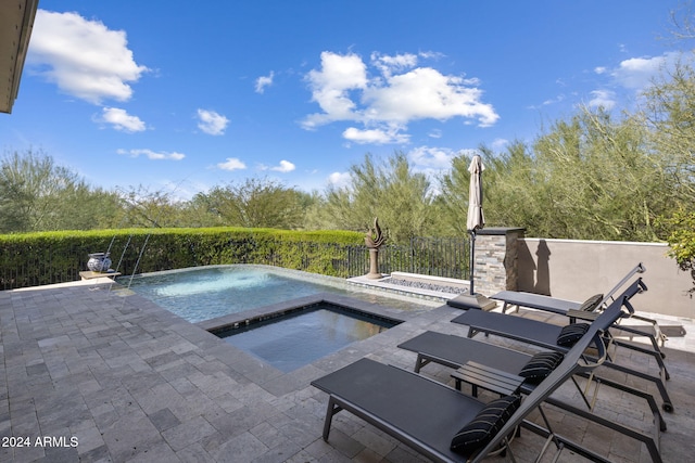 view of pool with a patio area, pool water feature, and an in ground hot tub