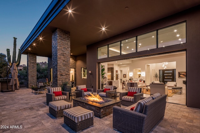 patio terrace at dusk with an outdoor living space with a fire pit