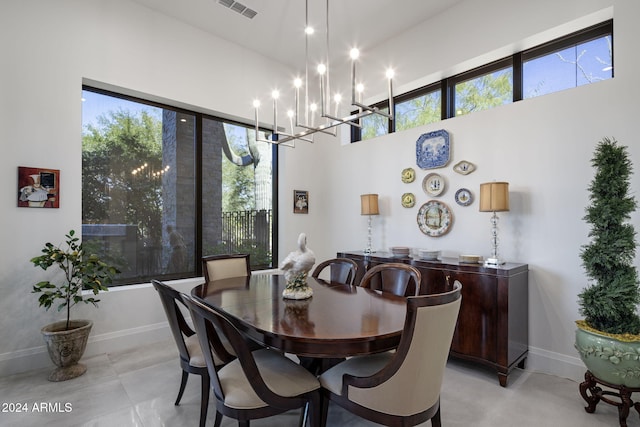 dining area with a chandelier and a towering ceiling