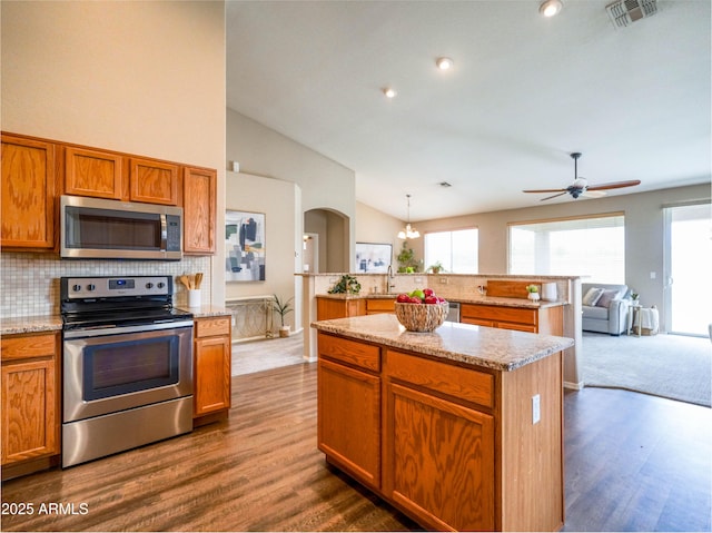 22986 S 208th St, Queen Creek, AZ 85142 - kitchen featuring stainless steel appliances, a kitchen island, vaulted ceiling, backsplash, and healthy amount of natural light