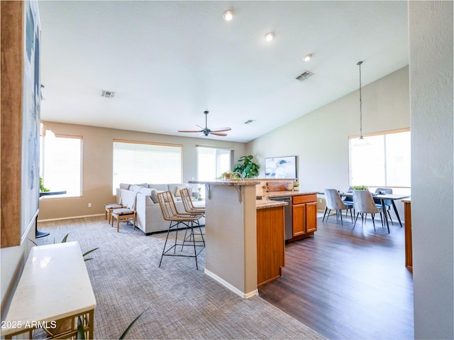 22986 S 208th St, Queen Creek, AZ 85142 - kitchen with a kitchen bar, brown cabinets, a ceiling fan, open floor plan, and baseboards
