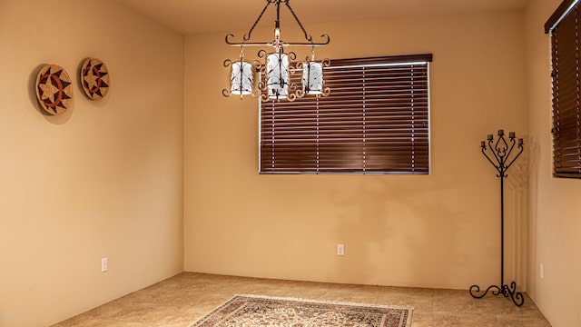 unfurnished dining area featuring an inviting chandelier and tile patterned flooring